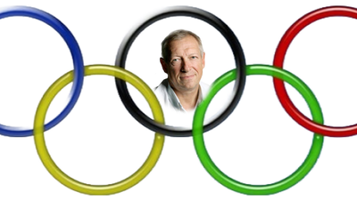 Mand smilende bag de olympiske ringe