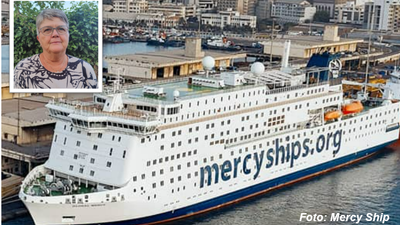 Et stort Mercy Ships-hospitalsskib lagde til nær en by med et indsat billede af et smilende menneske.