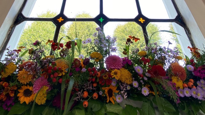 En stor vindueskarm med farvede blomster under et vindue.