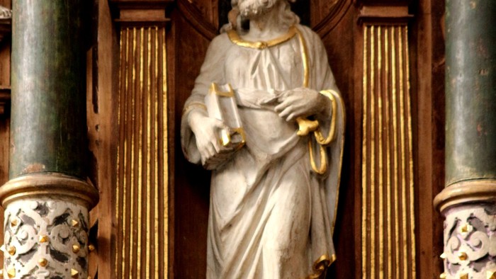 Die Statue eines Mannes mit Buch und Feder in einem goldenen Rahmen