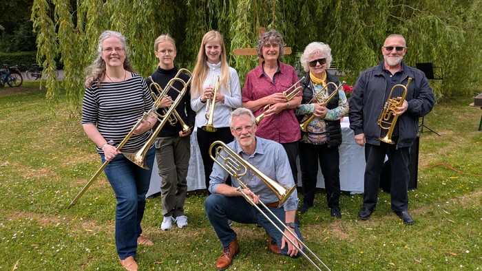 Eine Gruppe von Musikern posiert im Park mit ihren Instrumenten