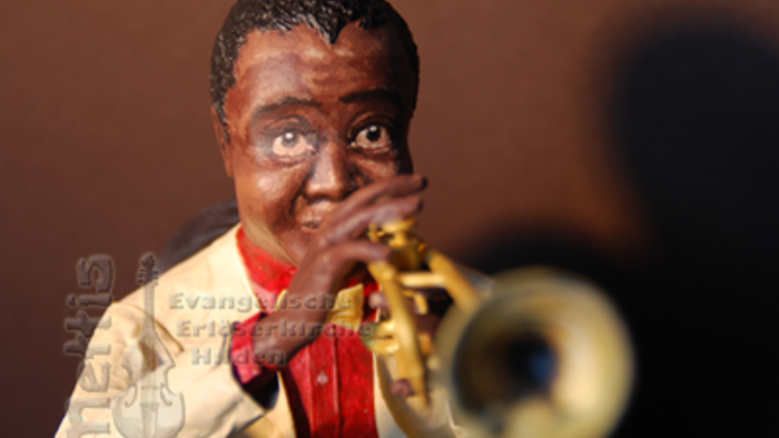 Eine Figur eines Mannes spielt eine Trompete.