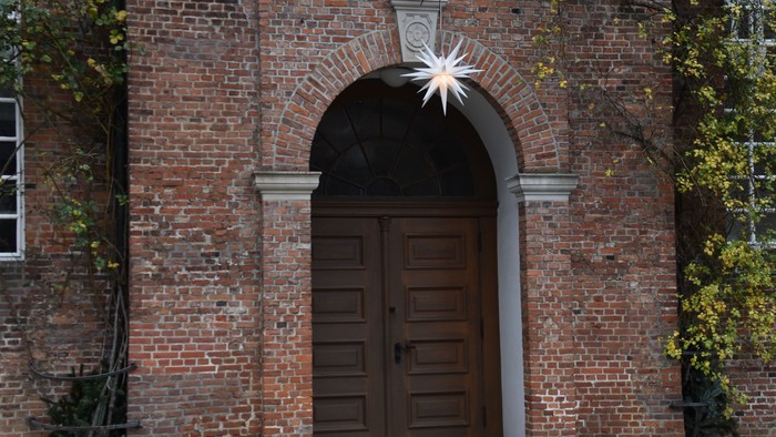 Ein hölzernes Tor in einem Ziegelgebäude mit einem Stern darüber