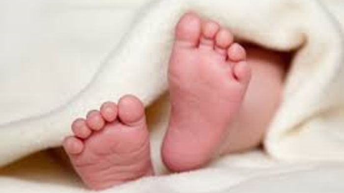 En spæd barnesåls par, delvist dækket af et blødt, hvigt tøj.