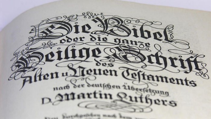 Das Bild zeigt eine alte deutsche Bibel mit verzierter Schrift.