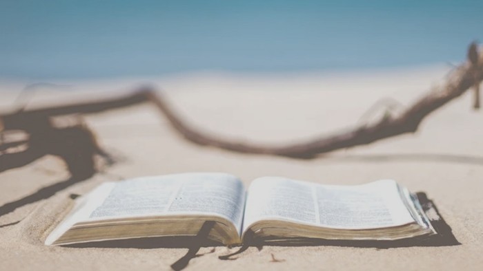 Offenes Buch im Sand am Meer