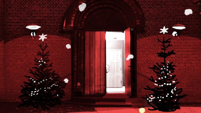 En rød mur med en dør og to juletræer på hver side, dekoreret med snø og stjerner.