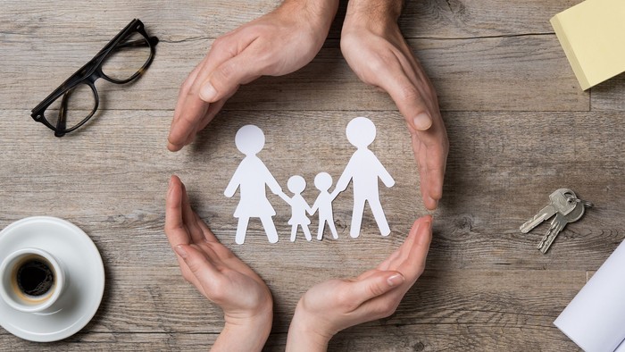 vier Hände umschließen Menschen in einem Kreis