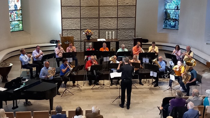 Ein Orchester probt in einer Kirche unter der Leitung eines Dirigenten