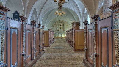 En lang, smuk korridor med buegange og lyse belysninger.