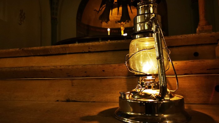 En lyseglødende oljelampe står på en træbord.