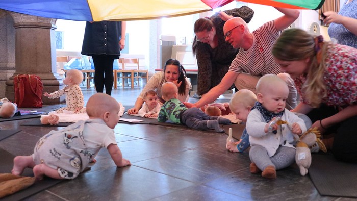 Børn spiller under regnbuetelt i legeværelset