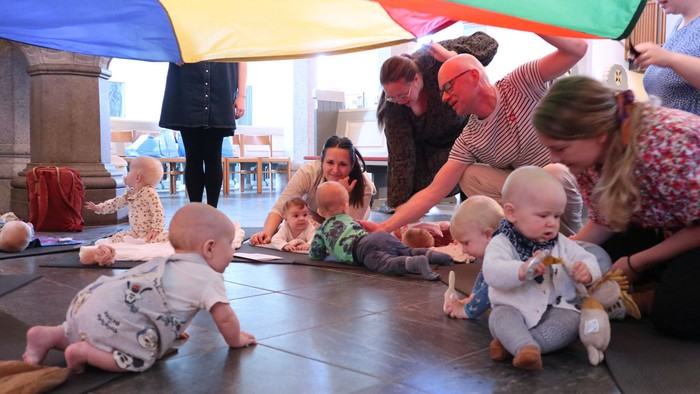Børn spiller under regnbuetelt i legeværelset