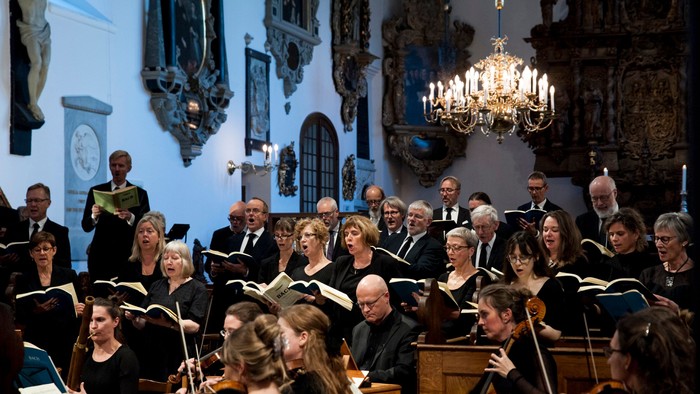 En kor og orkester optræder i en kirke.