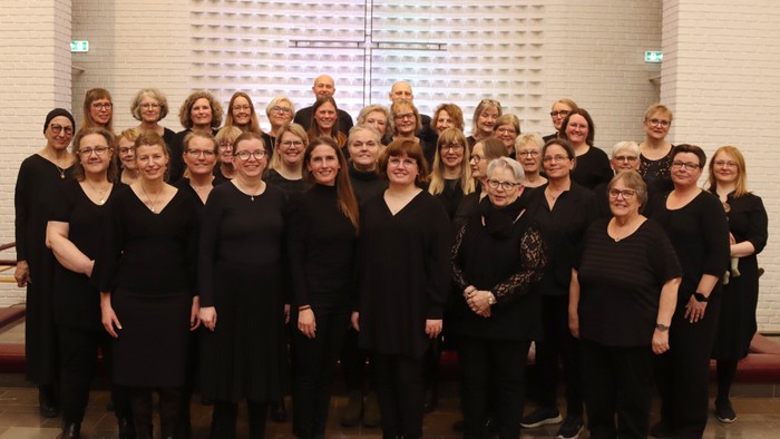 En gruppe kvinder i mørke klæder samlet til et billede