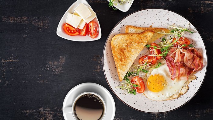 Frühstücksteller mit Spiegelei und Toast, eine Tasse Kaffee