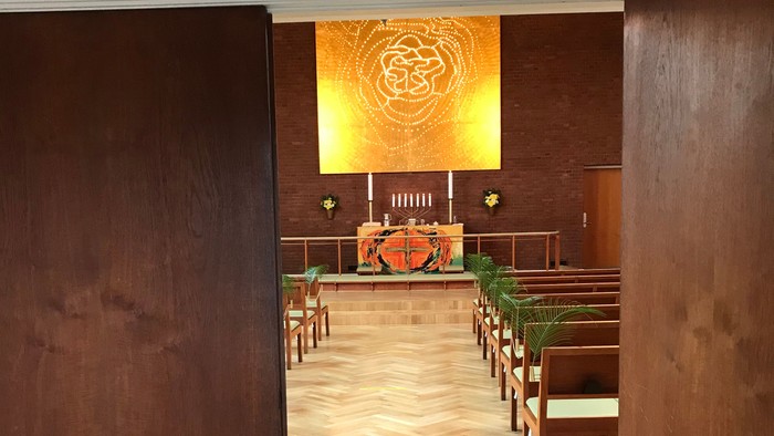 Indgang til kirke med alter og bænke.