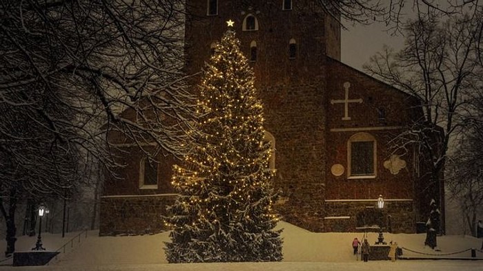 Weihnachtsbaum vor Kirche im Schnee