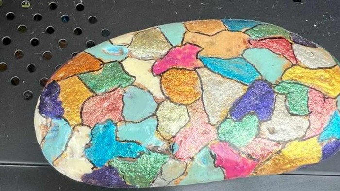 En farverig og mønstret keramikflise på sort baggrund