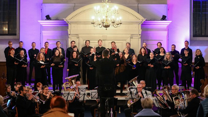 Et kor og orkester, der optræder i en stor sal.