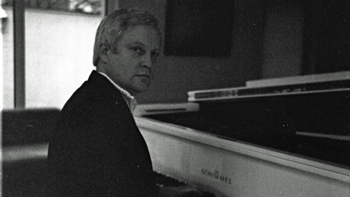 Ein Mann spielt Klavier in einem Raum.