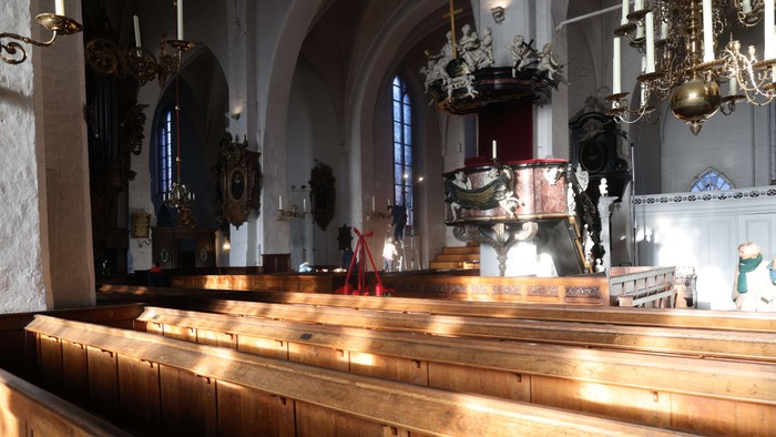 Innenraum einer Kirche mit Holzbänken und altem Mobiliar