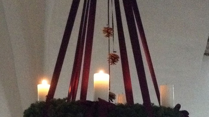 En kransekage med grønne blomster og lysende lygter hænger fra loftet