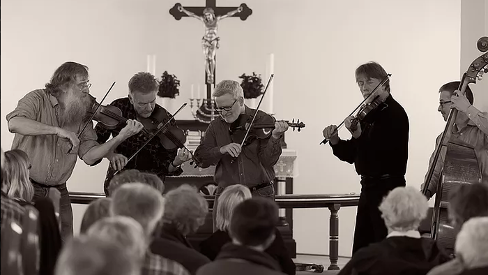 En gruppe musikere spiller i en kirke.