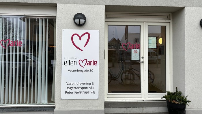 Forretning med hjerteemotikon og plant i pot på træde.