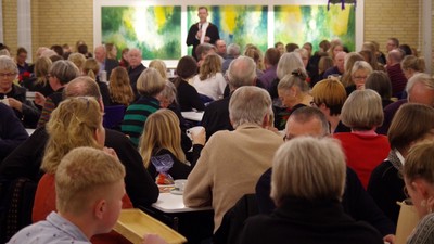 En folkemængde ser en præsentation i et lokal.