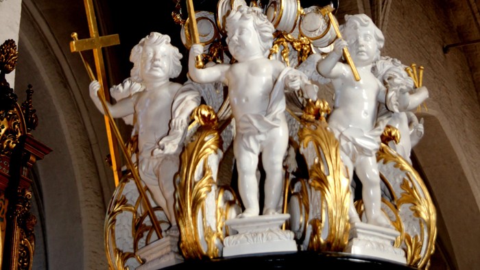 Die Statue zeigt weiße Engelfiguren mit goldenen Akzenten in einer Kirche.