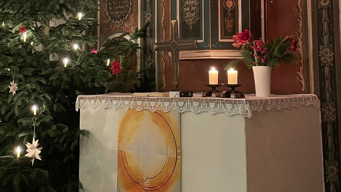 Weihnachtsdekoration in Kirche mit Christbaum und Krippenbild