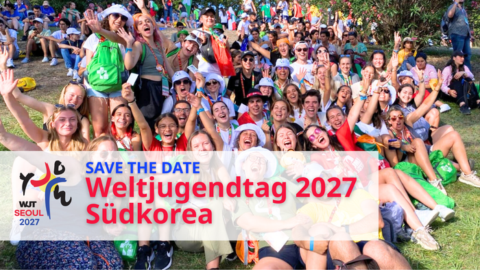 Gruppe von Menschen, die für ein Foto mit einem Banner für den Weltjugendtag 2027 in Korea posieren.