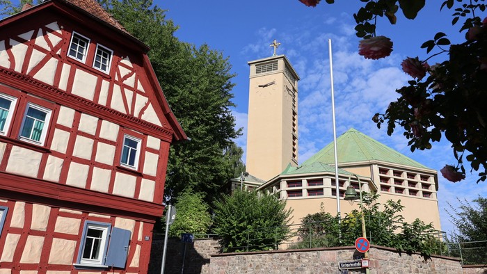 Kirche Niederursel von vorn mit Rosen