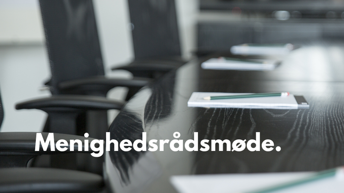 Mødelokale med bord og stoler.