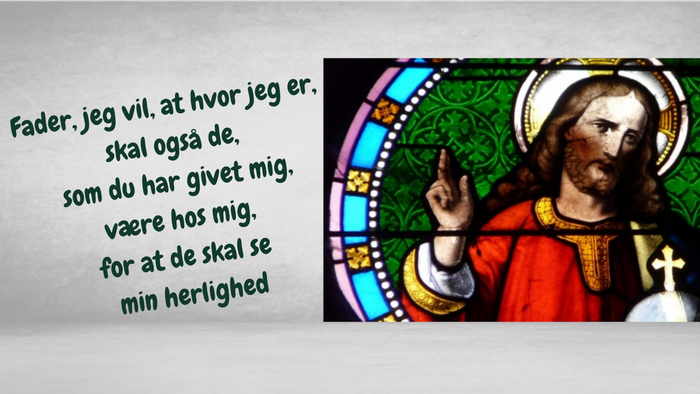 Billedet viser Jesus Kristus i et glasmaleri med en latinsk tekst.