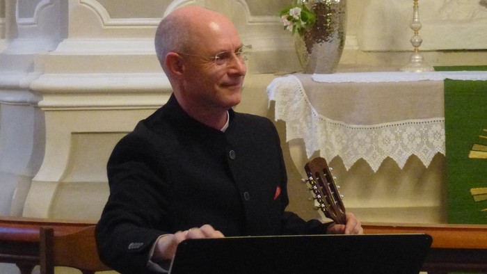 Mand spiller guitar i kirke.