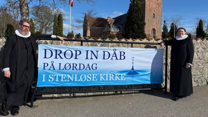To præster holder banner med budskab om bøn for klima