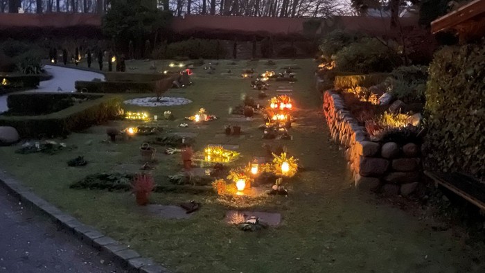 En have med lysende lygter og små badeanlæg i natten