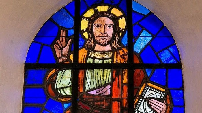 Glassmaleri af Jesus med bog og halo.