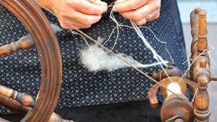 Frau am Spinnrad - Symbolbild