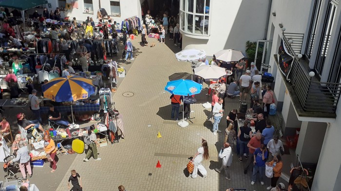 Belebter Freiluftmarkt mit vielen Menschen und Ständen.