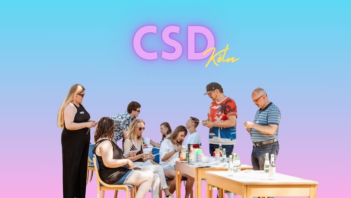 Eine Gruppe von Menschen sitzt an einem Tisch und isst, während eine Frau daneben steht.