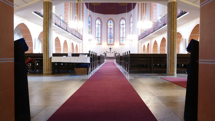 Die Kirche mit hohem Gewölbe und rotem Teppich.