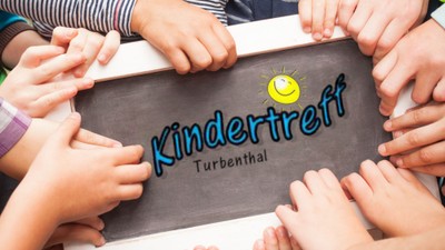 Kinderhände schreiben "Kindertreff Turbenthal" auf Tafel