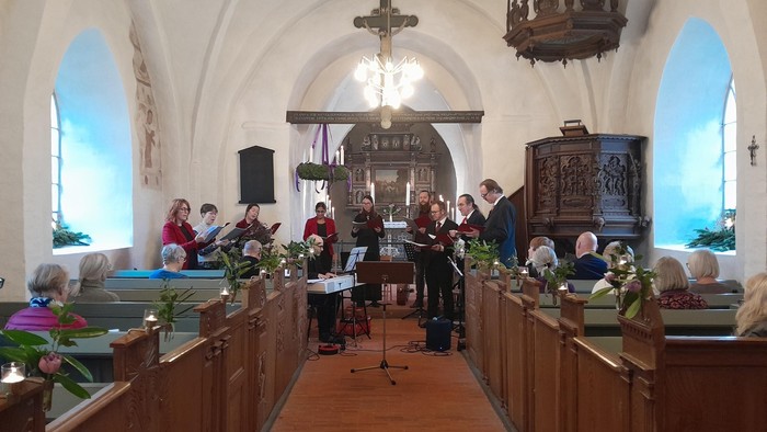 En kirke med en sanggruppe og en præst ved alteret
