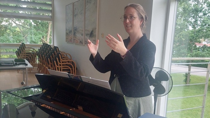 Kvinde ved piano i hhv. sal