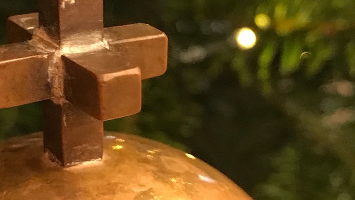 En lysende julekugle med et kors på toppen