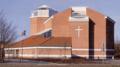 En stor, rød kirke med et stort kors på fasaden og en tårnagtig struktur på taket