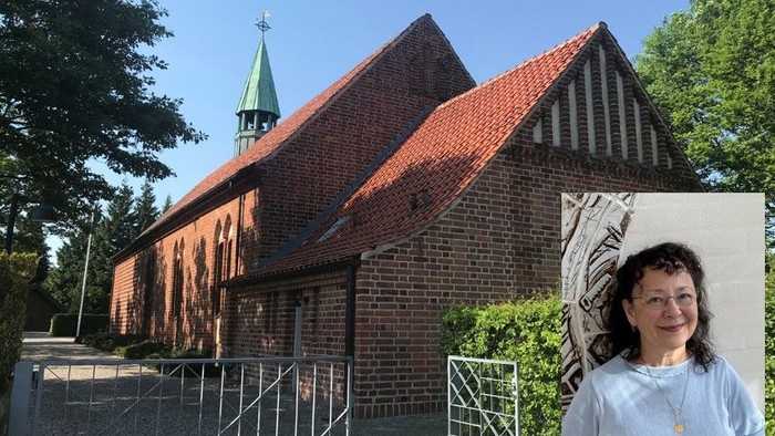 Kvinde står foran rødfarget kirke med spiret og træer i baggrunden